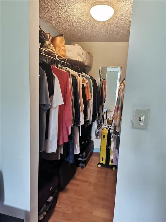 9449 Boca Cove Circle, Unit 908 Boca Raton, FL 33428 - Photo 7 of 12 a view of walk in closet with clothes and shoes