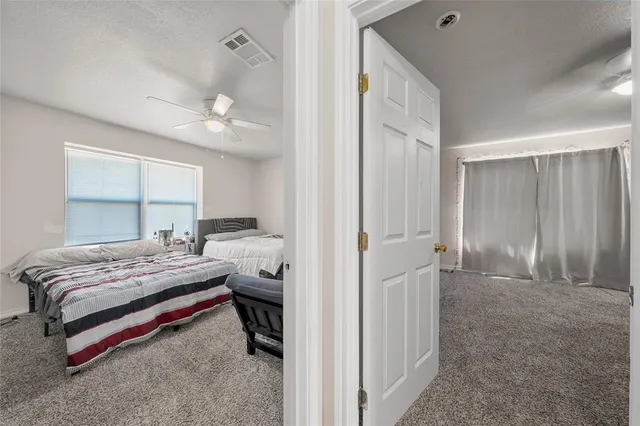 a spacious bedroom with a bed and a chandelier