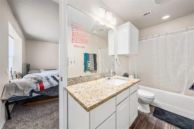 a en suite bathroom with a granite countertop sink and a mirror