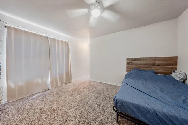 a bedroom with a bed and a ceiling fan