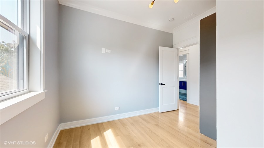 4115 North Ridgeway Avenue Chicago, IL 60618 - Photo 21 of 46 a view of an empty room with wooden floor and a window