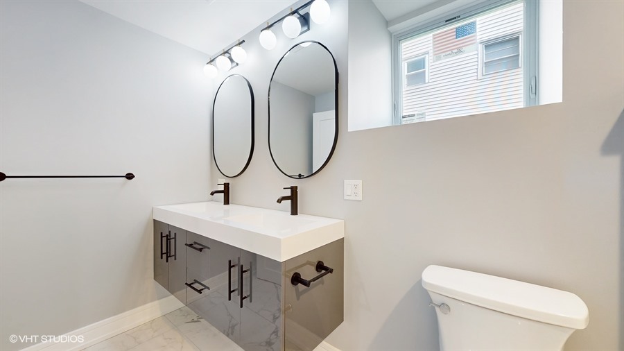 4115 North Ridgeway Avenue Chicago, IL 60618 - Photo 37 of 46 a bathroom with a toilet sink and mirror