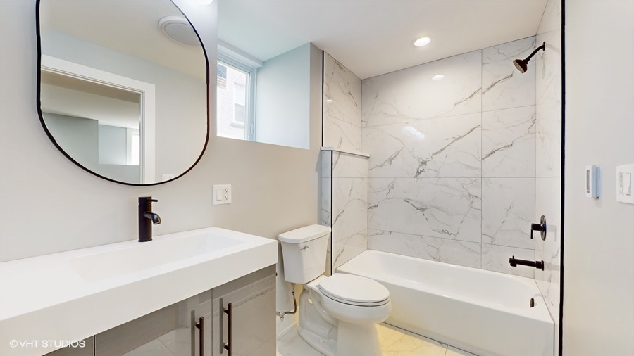 4115 North Ridgeway Avenue Chicago, IL 60618 - Photo 38 of 46 a bathroom with a sink a toilet and a mirror