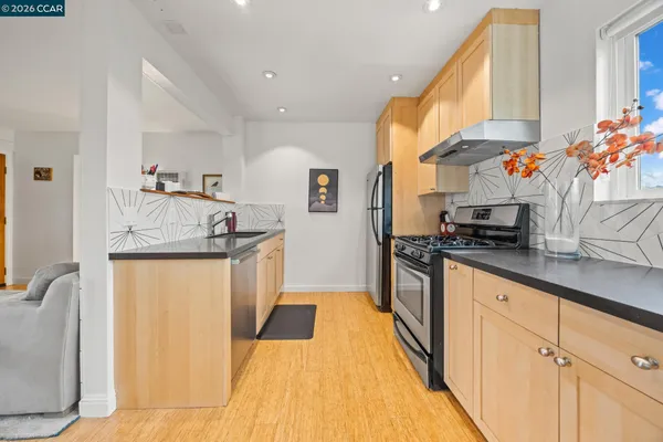 a kitchen with stainless steel appliances granite countertop a sink and a refrigerator