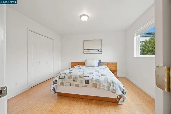 a white bed sitting in a bedroom next to a window