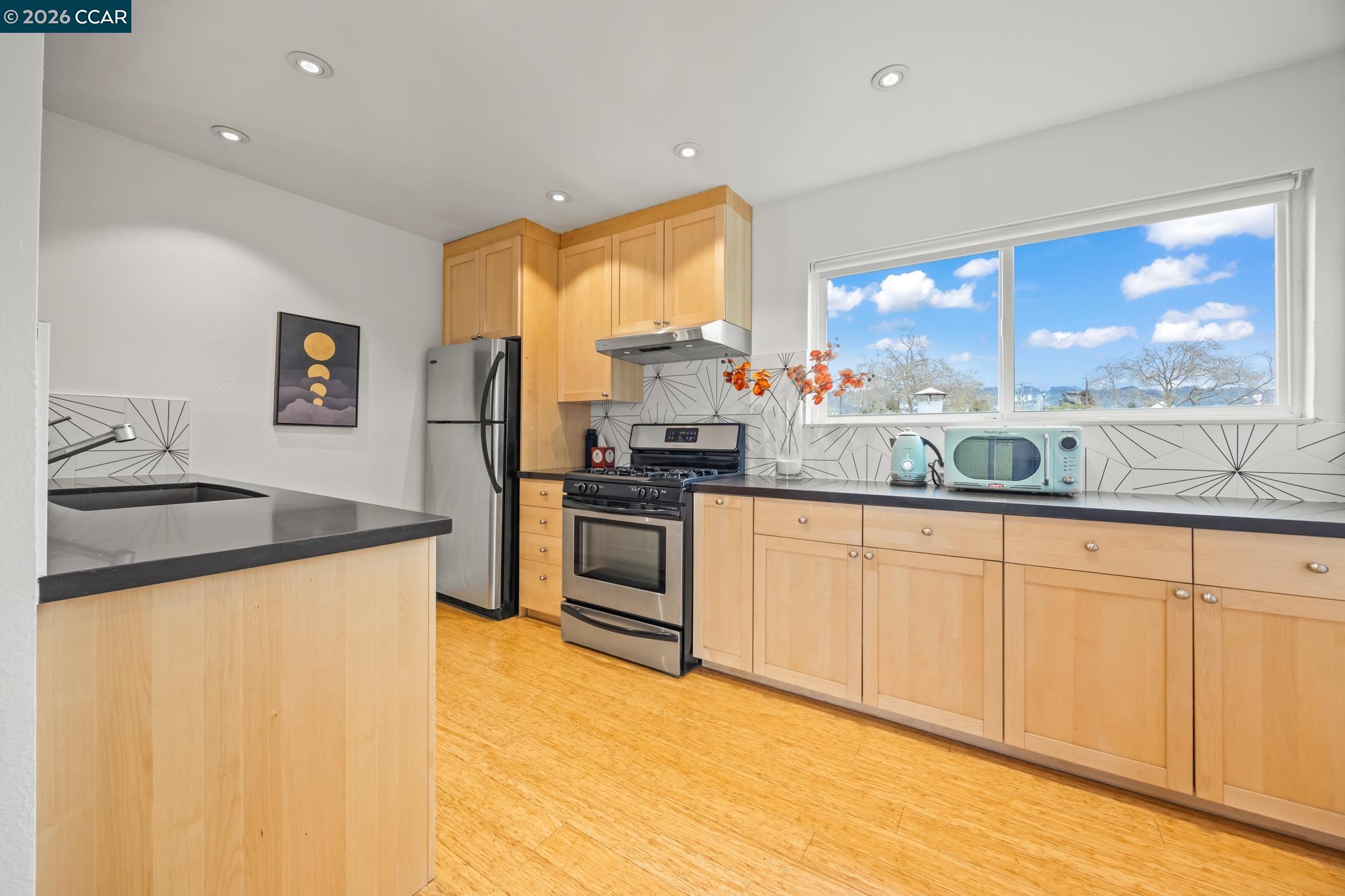 2327 Tenth Street, Unit 4 Berkeley, CA 94710 - Photo 9 of 39 a kitchen with granite countertop white cabinets and stainless steel appliances