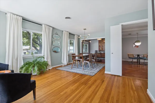 a furnished livingroom with a window and wooden floor
