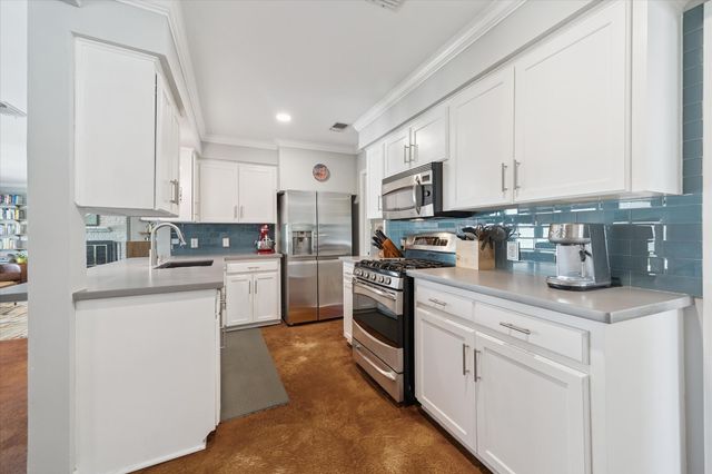 a kitchen with white cabinets and sink