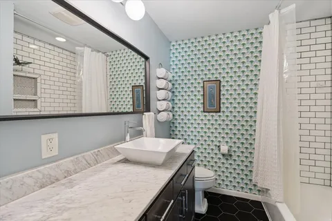 a bathroom with a sink a toilet and mirror