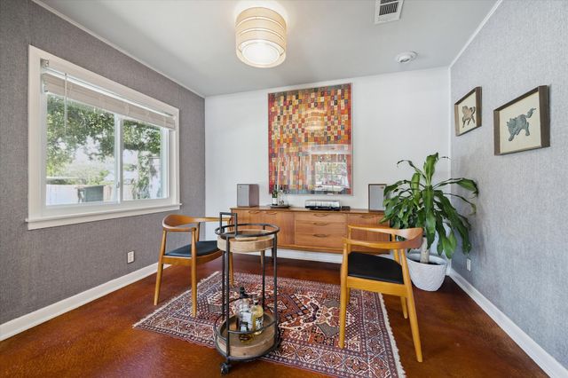 a dining room with wooden floor a chandelier a wooden table and chairs