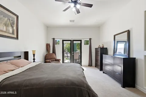 a spacious bedroom with a bed and ceiling fan