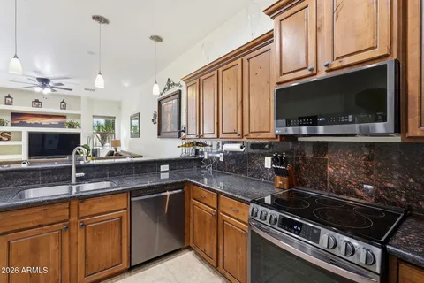 a kitchen with stainless steel appliances granite countertop a stove a sink dishwasher and a refrigerator