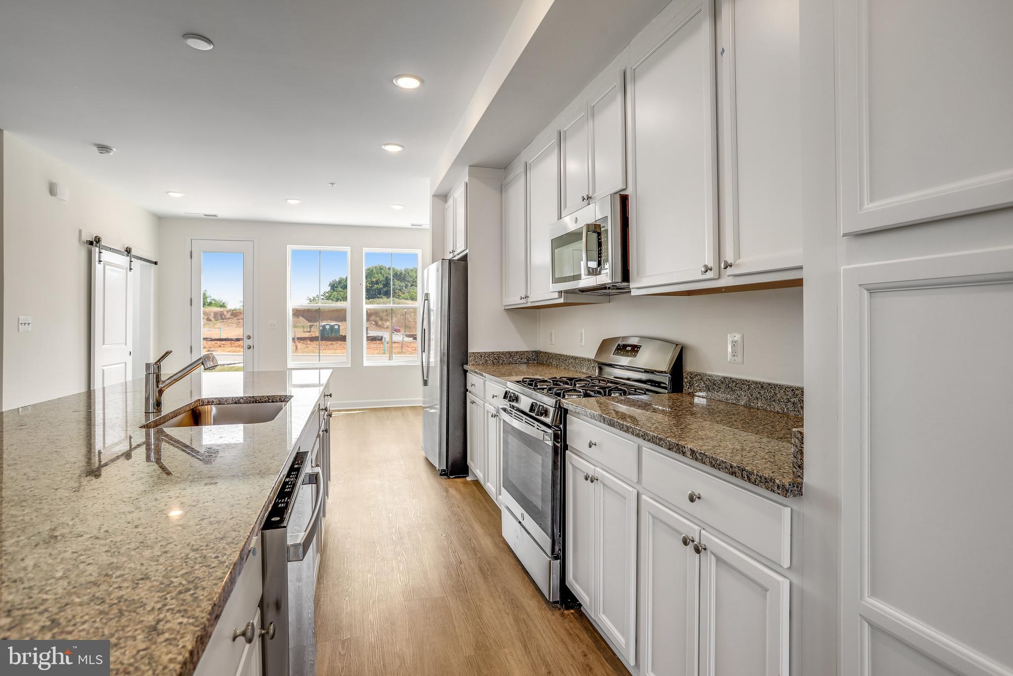 1811 Shookstown Road Frederick, MD 21702 - Photo 11 of 37 a kitchen with stainless steel appliances granite countertop a lot of counter space and wooden floors