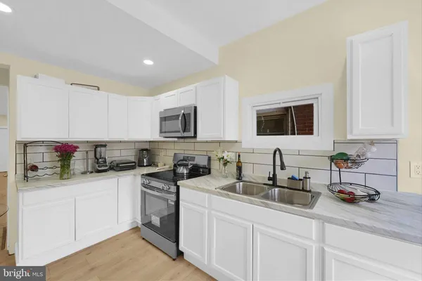 a kitchen with a sink stove top oven and cabinets