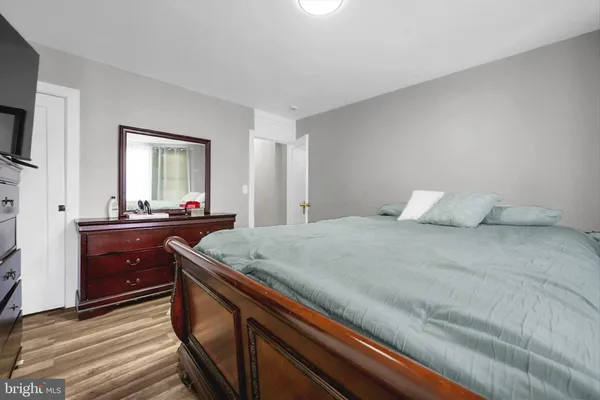 a spacious bedroom with a bed and a dresser