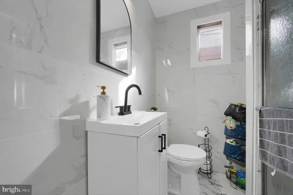 a bathroom with a toilet sink and mirror