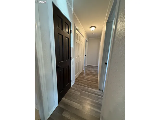 a view of a hallway with wooden floor