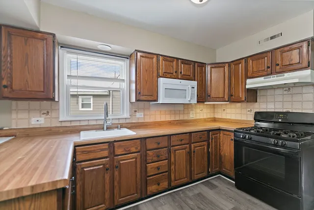 a kitchen with stainless steel appliances granite countertop a sink stove and cabinets