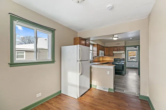 a kitchen with a refrigerator and a stove top oven