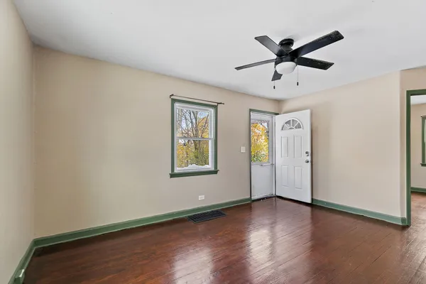 a view of a big room with wooden floor and windows