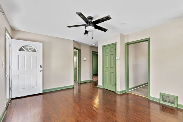 a view of a livingroom with a ceiling fan wooden floor and a ceiling fan