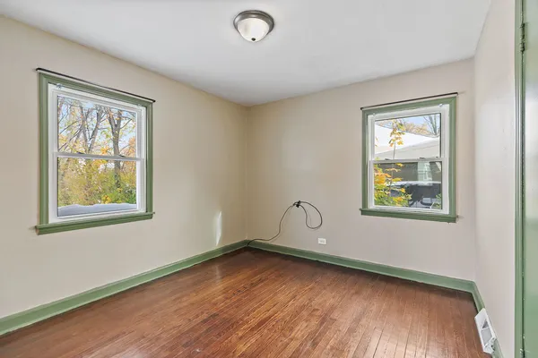 a view of a room that has a window and wooden floor