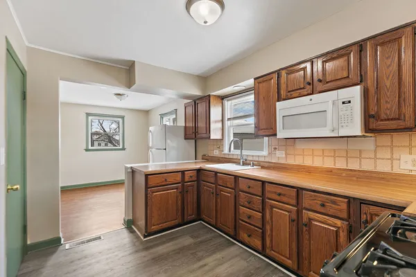 a kitchen with stainless steel appliances granite countertop a sink dishwasher stove and cabinets with wooden floor