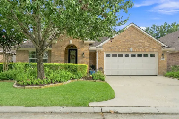 a front view of a house with a garden and yard