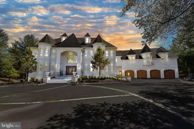 a view of a white house with a clock tower in middle of a road