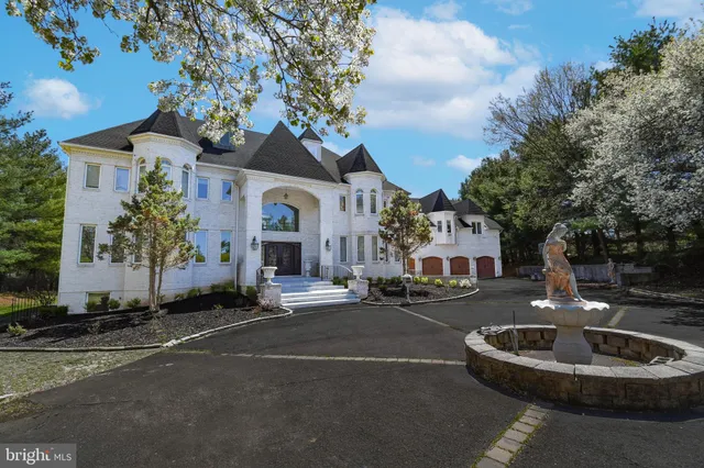 a front view of a house with garden and trees