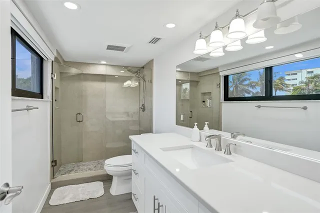 a bathroom with a sink a toilet and shower