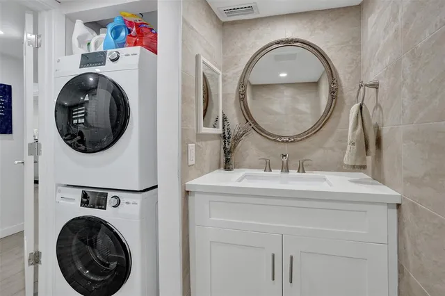 a bathroom with a sink a mirror and a washer