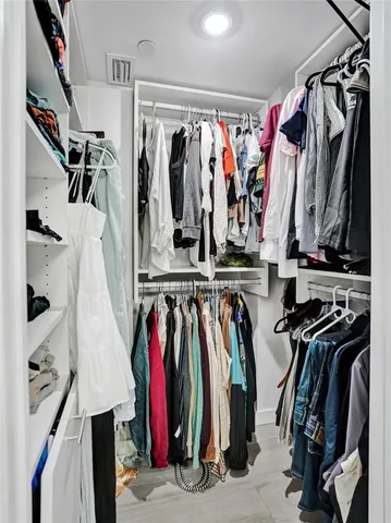 a view of walk in closet with clothes