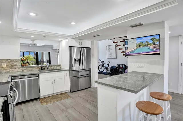 a kitchen with stainless steel appliances granite countertop a sink and a refrigerator