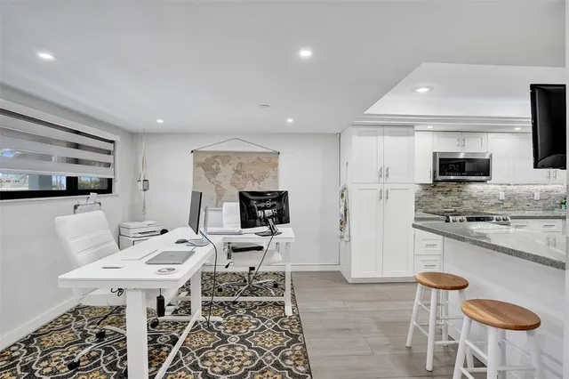 a kitchen with stainless steel appliances kitchen island granite countertop a sink and a refrigerator