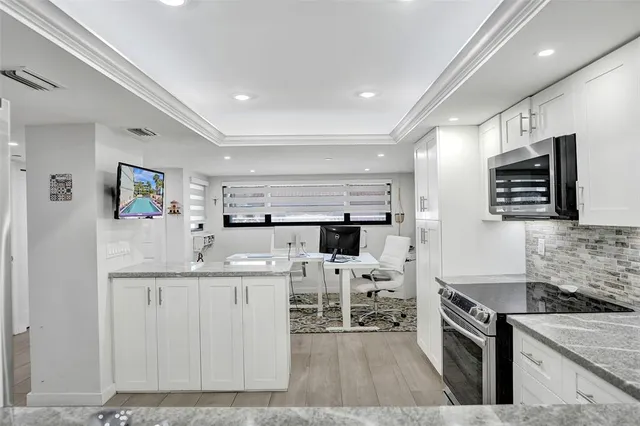 a kitchen with stainless steel appliances kitchen island granite countertop a stove and a sink