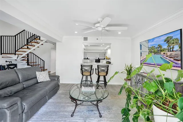 a living room with patio furniture and a potted plant