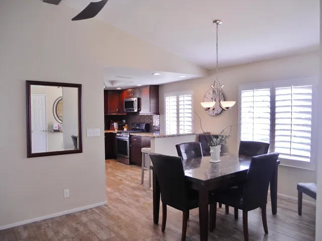 a kitchen with stainless steel appliances granite countertop a refrigerator a stove and a sink with wooden floor