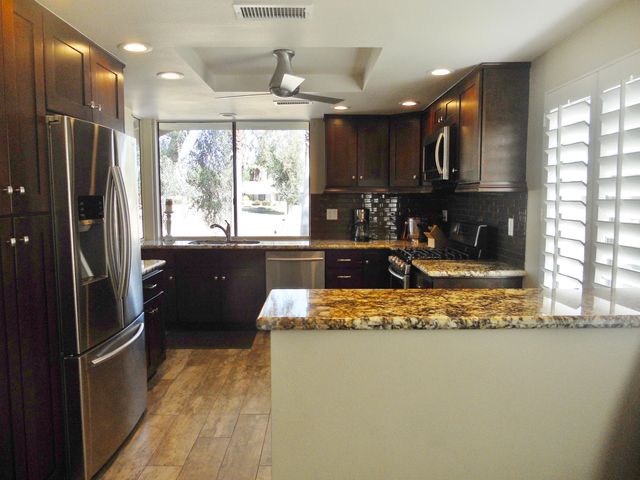 a dining room with a table chairs and a kitchen view