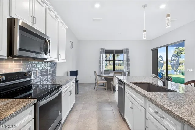 a kitchen with stainless steel appliances granite countertop a sink stove and microwave