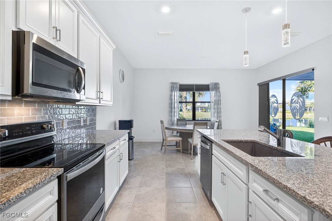 4351 Washington Place Ave Maria, FL 34142 - Photo 11 of 44 a kitchen with stainless steel appliances granite countertop a sink stove and microwave