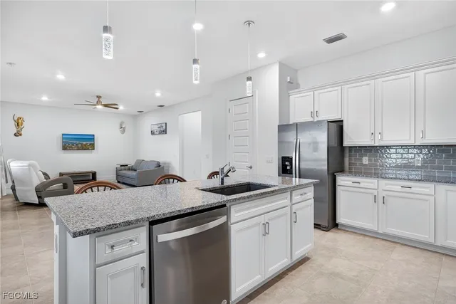 a kitchen with stainless steel appliances granite countertop refrigerator sink and cabinets