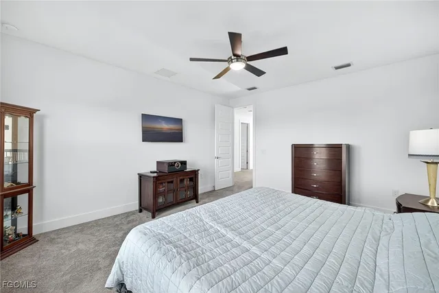 a bedroom with a bed and a flat tv screen on dresser