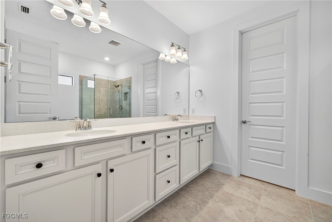 4351 Washington Place Ave Maria, FL 34142 - Photo 19 of 44 a bathroom with a double vanity sink and a mirror