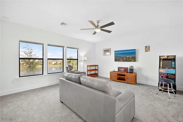 a living room with furniture and a ceiling fan