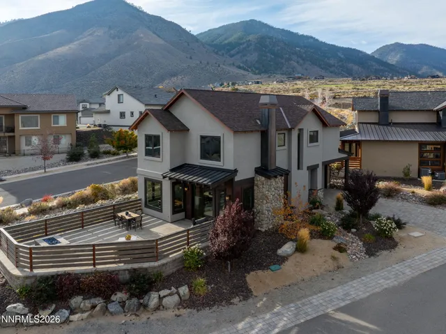 a front view of a house with a garden and mountain view