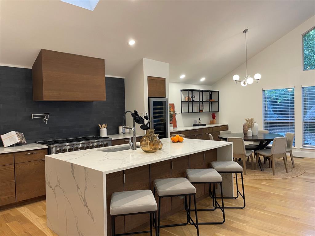 a kitchen with a dining table chairs and a sink