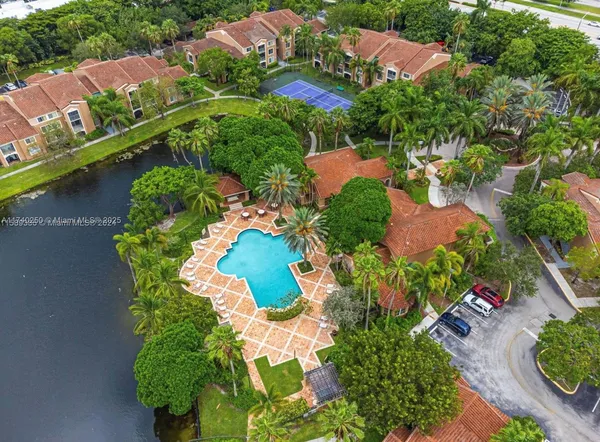 an aerial view of a house with a yard and lake view