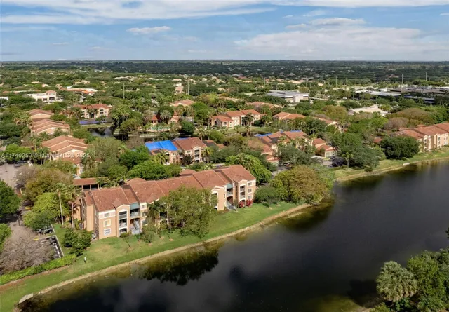 an aerial view of residential houses with outdoor space and lake view