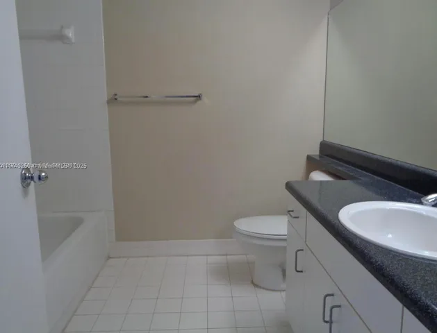 a bathroom with a granite countertop toilet and a sink